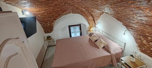 a bedroom with a bed in a room with a brick ceiling at Casetta sul mare in Savona