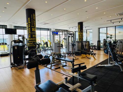 une salle de sport avec de nombreux équipements cardio dans un bâtiment dans l'établissement Wakacyjny apartament w Courtyard Long Beach Holiday Resort, à Iskele