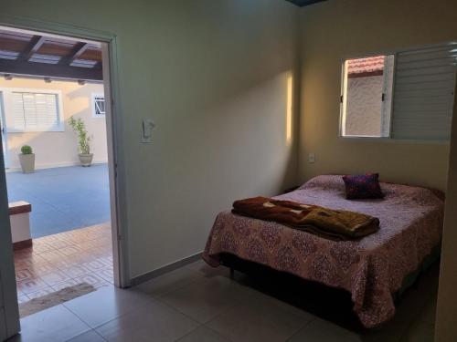 a bedroom with a bed in the corner of a room at Pousada Jandi in São Miguel Arcanjo