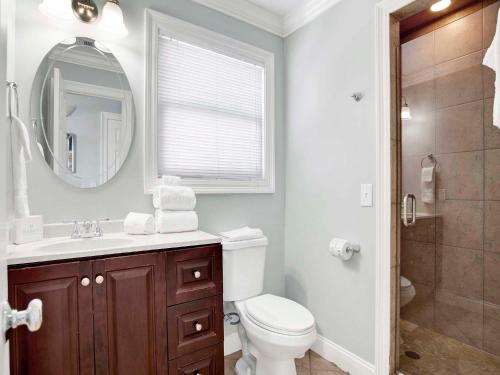 a bathroom with a toilet and a sink and a mirror at Serenity Eden in Perdido Key