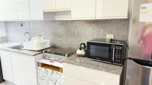 a kitchen with a microwave and a sink at The Legends Family Apartment in Lima