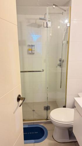 a bathroom with a glass shower with a toilet at The Legends Family Apartment in Lima