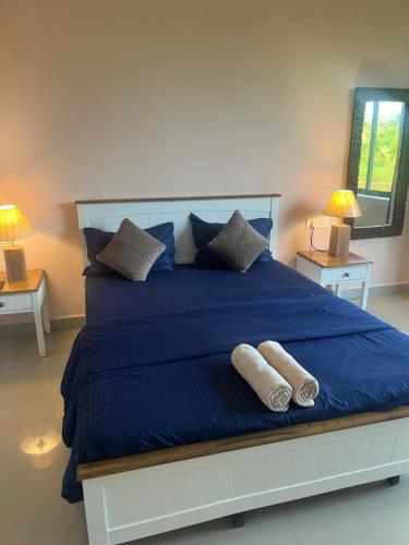 a large blue bed with two pillows on it at Hotel 14 Pods Morjim in Morjim