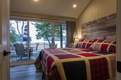 a bedroom with a bed and a balcony with a view at Olga's Bay Lake House in Minett