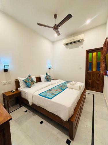 a bedroom with a bed and a ceiling fan at Hotel Muskan Heritage in Jaisalmer
