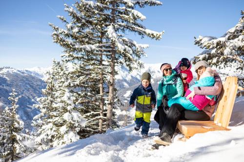 a family sitting on a ski lift in the snow at Ferienwohnung Garber in Zell am Ziller