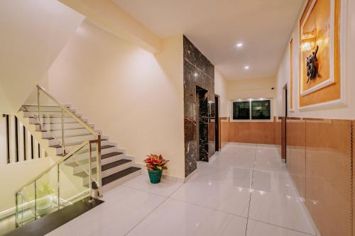 a hallway of a house with a staircase and a potted plant at Victoria Suites Airport Hotel in Nedumbassery