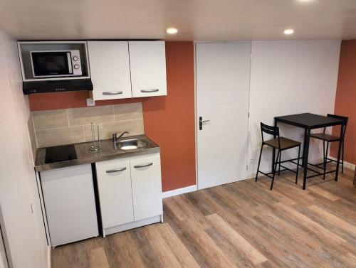 a small kitchen with a sink and a microwave at Ideal apartment with all confort in Ormes