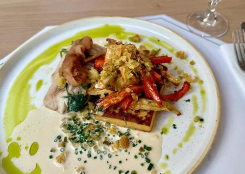 a plate of food with vegetables on a table at Hotel Toscania in Włoszakowice
