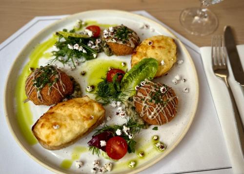 a plate of food with potatoes and vegetables on a table at Hotel Toscania in Włoszakowice