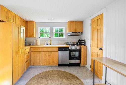 eine Küche mit Holzschränken und einem Herd in der Unterkunft Hamptons Cottage, Sleeps 7 in East Quogue