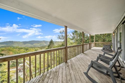 a porch with a chair and a view of the mountains at Mountain Sunrise in Blowing Rock