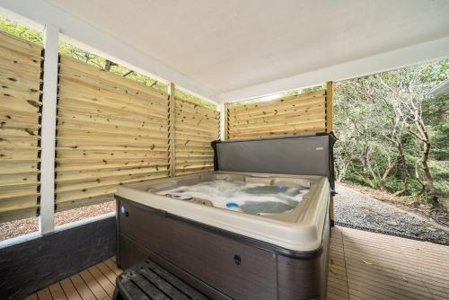a bath tub sitting in a room with wooden walls at Mountain Sunrise in Blowing Rock