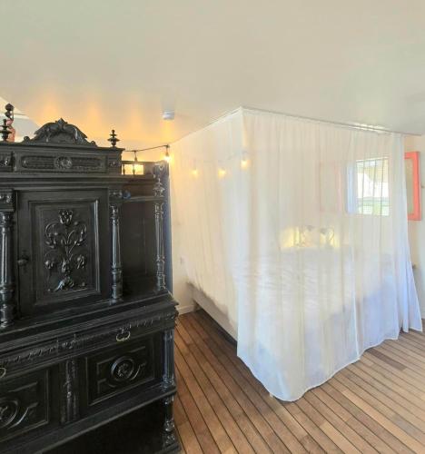 a black dresser in a room with a white curtain at Cosicocoon in Port-Vendres