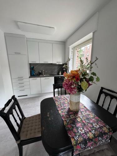 a kitchen with a table with a vase of flowers on it at Schwarzer Schwan in Kleve
