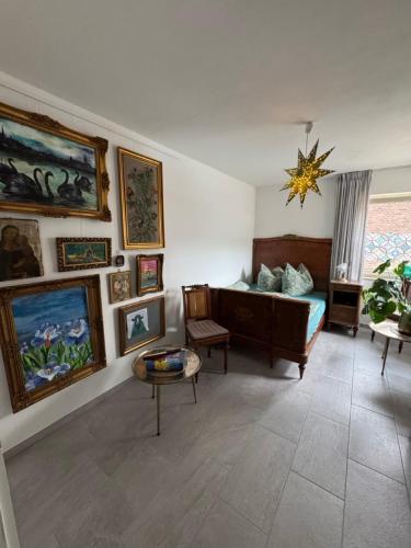 a living room with a couch and paintings on the wall at Schwarzer Schwan in Kleve