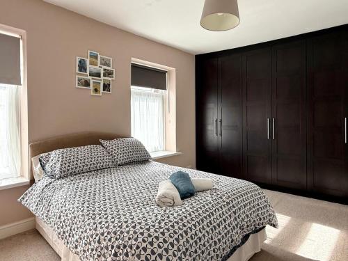a bedroom with a bed with a brown cabinet at 2 Bedroom House Penarth Town Centre in Cardiff