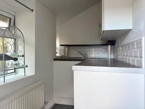 a kitchen with white cabinets and a sink at 2 Bedroom House Penarth Town Centre in Cardiff