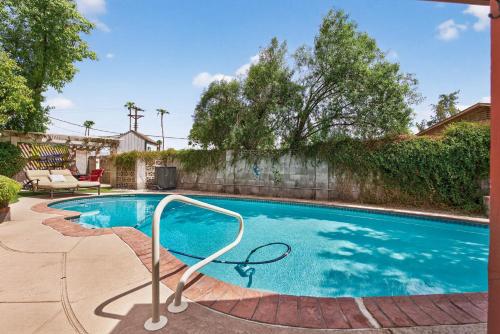 a swimming pool with a metal rail in a yard at Pineapple Oasis - Heated Pool, ASU, Sleeps 12 in Tempe