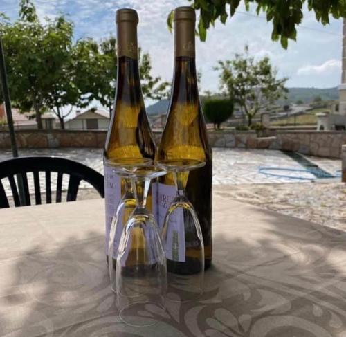 due bottiglie di vino sedute sopra un tavolo di Pomares Country House a Paderne