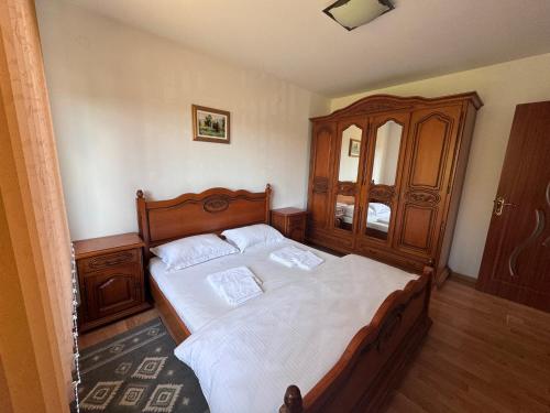 a bedroom with a wooden bed and a wooden cabinet at Casa Alexana in Gura Humorului