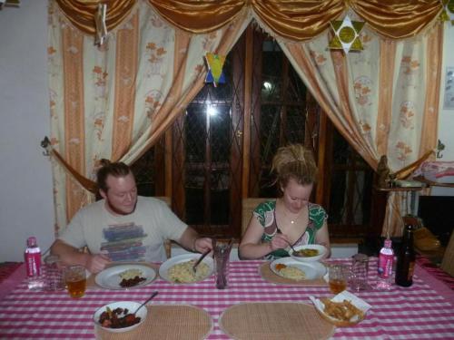 a man and a woman sitting at a table with plates of food at The villa sunshine kadawala in Dunagaha