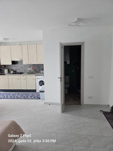a kitchen with white cabinets and a open door at Take your breath away - before driving on! in Jēkabpils