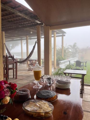 a wooden table with food and drinks on a patio at Recanto flor do maracujá in Ubajara