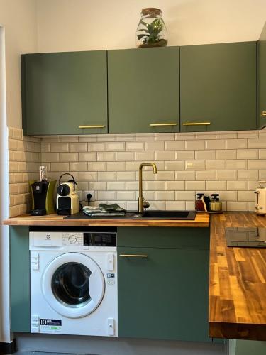 een keuken met een wasmachine en een wastafel bij L'Appart De Papa in Saverne