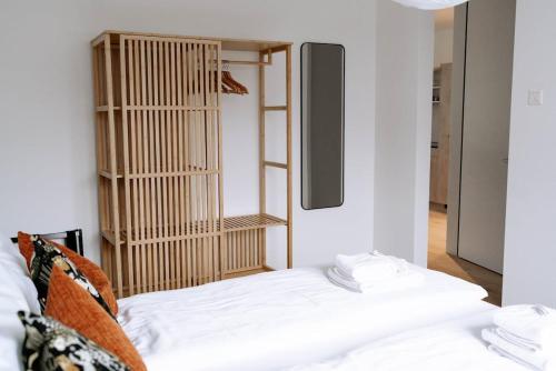 a bedroom with a white bed and a shelf at SimpleSparks I Luzern I Andermatt I Natur I Family in Altdorf