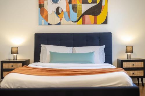 a bed with a blue headboard and two night stands at Artful 3BR in Montreal Village in Montréal
