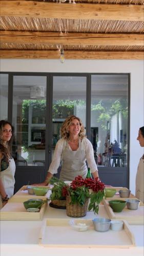 a woman standing at a table with bowls and flowers at Dimora Dei Semplici in Ostuni