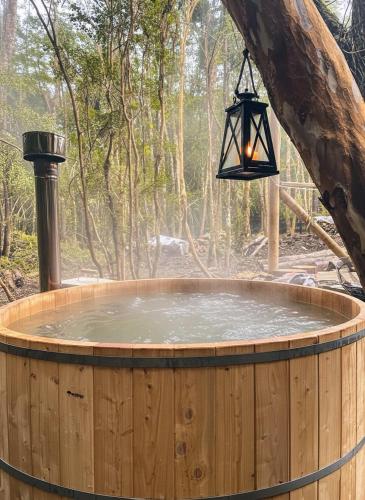 a hot tub with a light hanging from a tree at Cabañas Alto del Bosque in Coñaripe