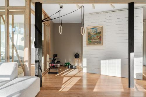 Il comprend un salon doté de murs blancs et de parquet. dans l'établissement Urban Architectural Retreat, à Tromsø