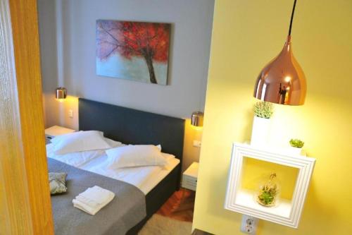 a bedroom with a bed and a picture on the wall at HOGOR Apartments in Sibiu