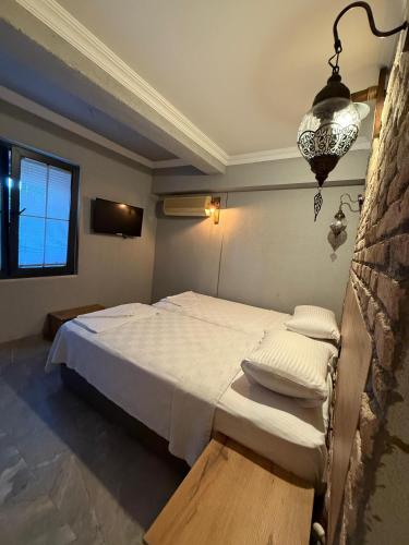 a bedroom with a bed and a chandelier at Ballı Butik hotel in Kayakoy