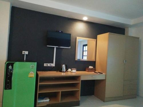 a kitchen with a green refrigerator and a desk at Bangkok Travel Suites Hotel in Nonthaburi