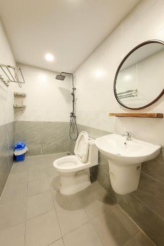 a bathroom with a sink and a toilet and a mirror at Lunaria Maison - Thư Thái Homestay in Ho Chi Minh City