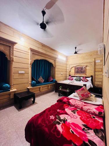 a bedroom with two beds and a table at Relax Inn Jaisalmer in Jaisalmer