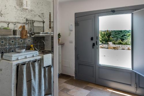 a kitchen with a door leading to a balcony at Trullo Picchiagiuda in Ostuni