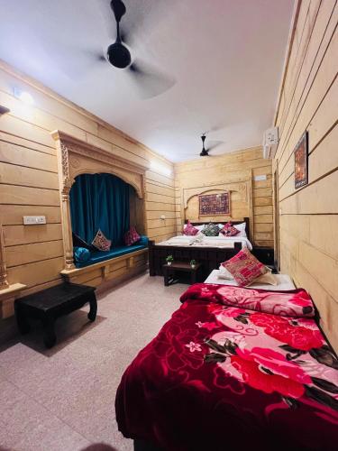 a bedroom with two beds and a table in it at Relax Inn Jaisalmer in Jaisalmer