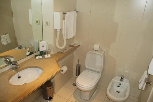 a bathroom with a toilet and a sink at Hotel Douro in Porto