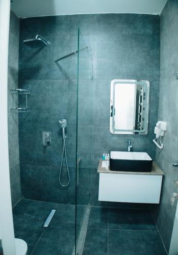 a bathroom with a shower and a sink and a mirror at AS Hotel Ganja in Ganja