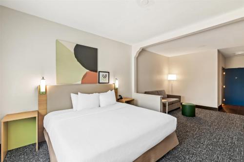 a hotel room with a large bed and a chair at Spark by Hilton Round Rock in Round Rock