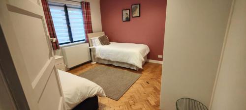 a small room with two beds and a window at Jersey Holiday Home in St Brelade