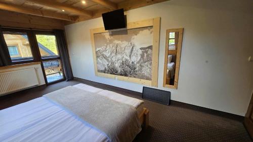 a bedroom with a bed and a painting on the wall at Chocholowska Zohylina pokoje in Chochołów