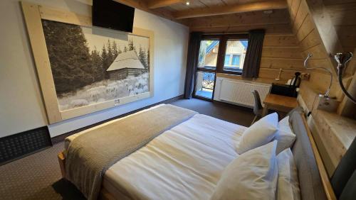 a bedroom with a bed and a large window at Chocholowska Zohylina pokoje in Chochołów
