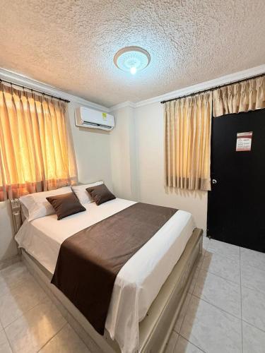 a bedroom with a large bed and a window at Hotel Buenavista Valledupar in Valledupar