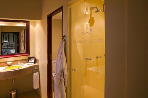a bathroom with a shower and a sink and a tub at Kuzuko Lodge in Addo
