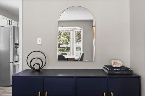 un espejo encima de un tocador negro en una habitación en Cozy Home Away from Home- 10MIN From DT Durham, en Durham